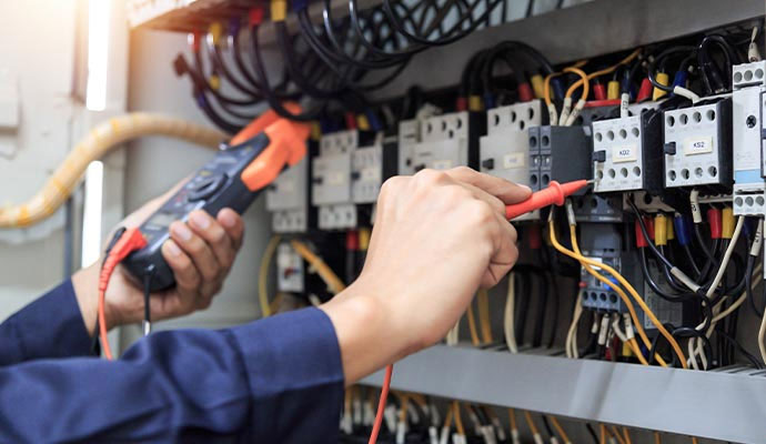 Electrician testing electrical control panel